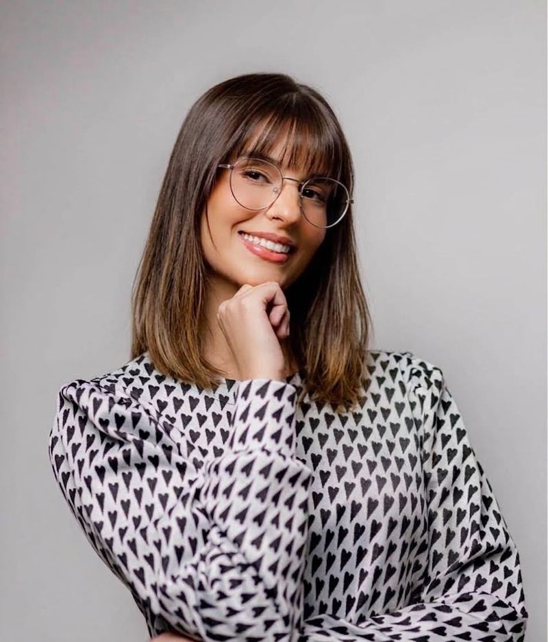 Monica Sarah Salomon, psicóloga, sorrindo com a mão apoiada no queixo